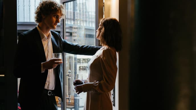 Erstes Date: Paar steht mit Weingläsern in der Tür