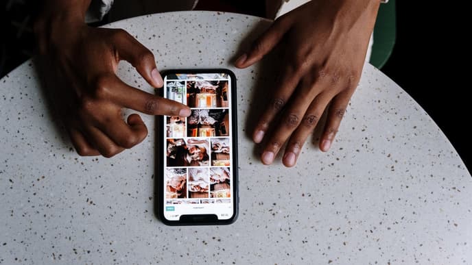 Hände auf dem Tisch mit Smartphone