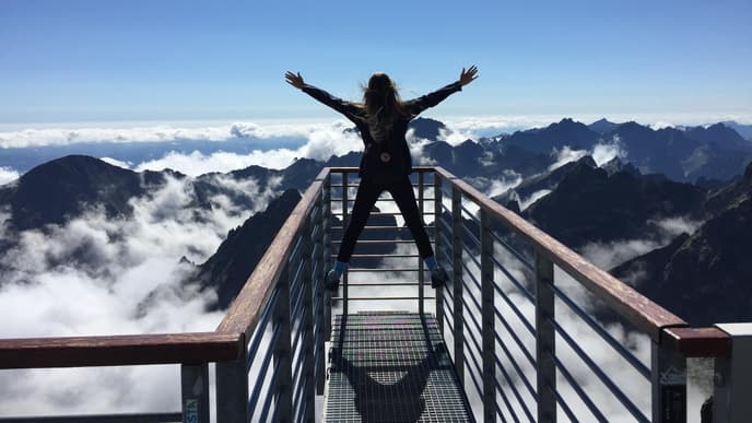 Frau steht auf einem Berg