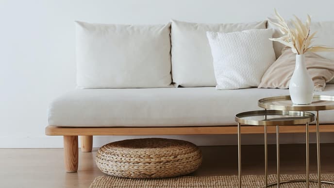 Beiges Sofa auf einem Jute-Teppich mit Deko