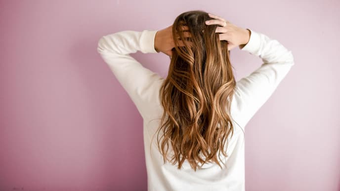 Frau faesst ihre Haare an