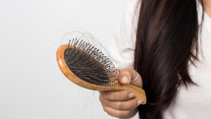 Frau hält Haarburste in der Hand 
