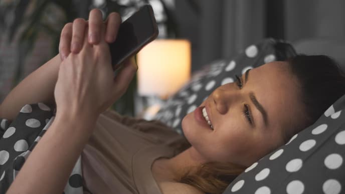 Gute Nacht mein Schatz: Frau liegt in Bett mit Handy
