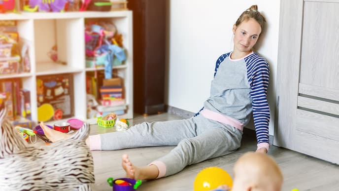 Mutter sitzt auf Boden