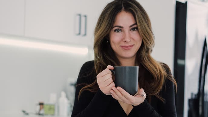 Junge Frau in der Küche mit einer Tasse in der Hand
