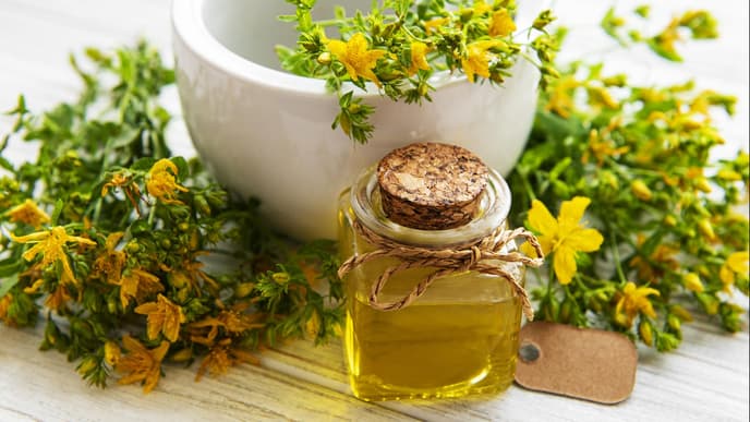 Johanniskrautöl: Flasche mit gelben Blüten