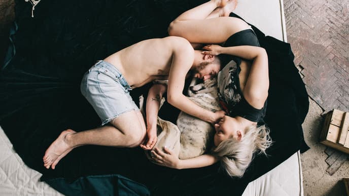 On-Off-Beziehung: Mann und Frau liegen mit Hund auf einem Bett 