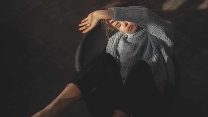 Horoskop Thema: Frau hält Arm vor Gesicht