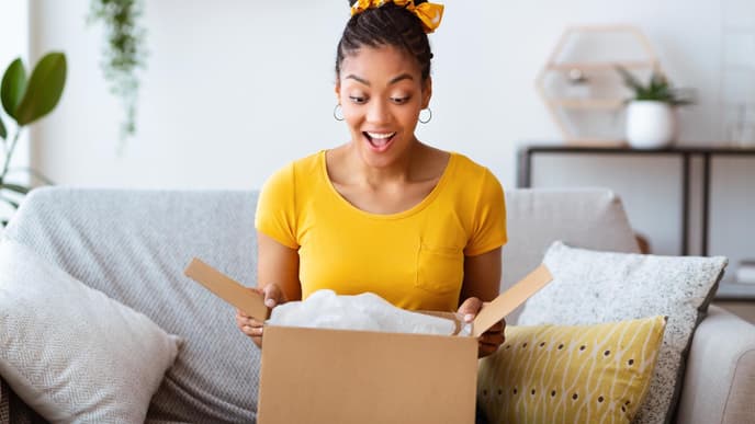 Frau im gelben T-Shirt öffnet Paket