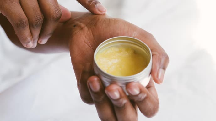 Hand hält Melkfett Creme Tube