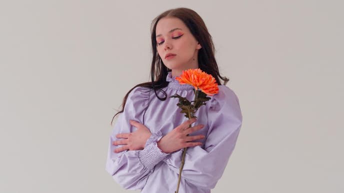Horoskop Thema: Frau im lilafarbenen Kleid mit Blume
