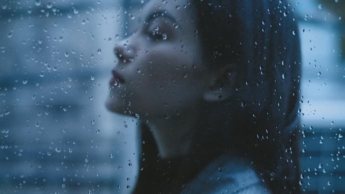 Horoskop Thema: Frau mit geschlossenen Augen im Regen