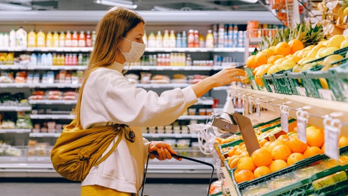 Corona: Frau mit Maske im Supermarkt
