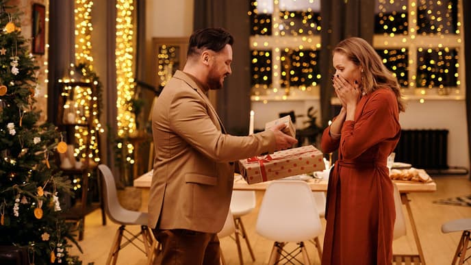 Mann überreicht Frau ein Geschenk