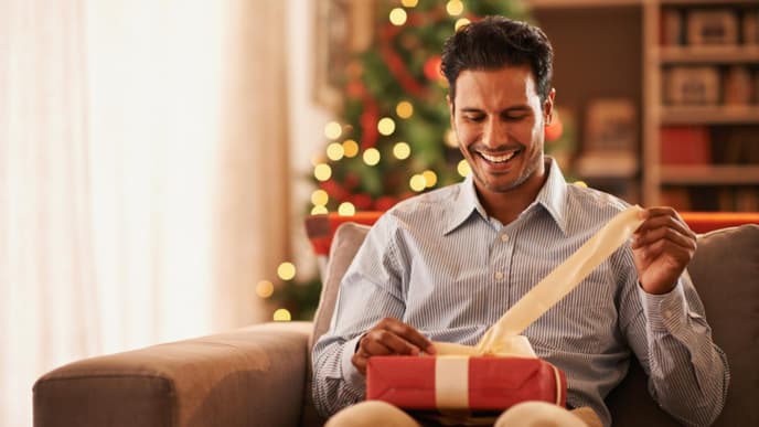 Mann öffnet ein Weihnachtsgeschenk
