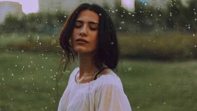 Frau steht im Regen
