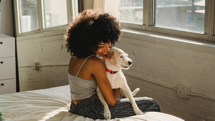 Frau mit Hund auf Bett