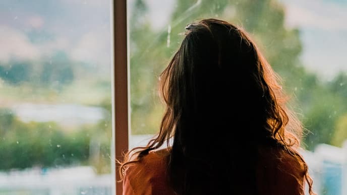 Frau schaut aus dem Fenster