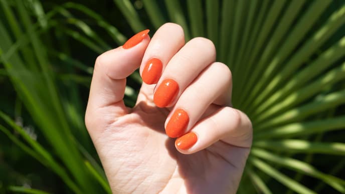 Lackierte Fingernägel in Orange