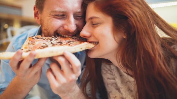 Mann und Frau teilen sich eine Pizza