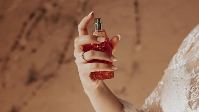 Frau mit Parfum in der Hand