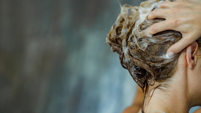 Frau wäscht sich die Haare
