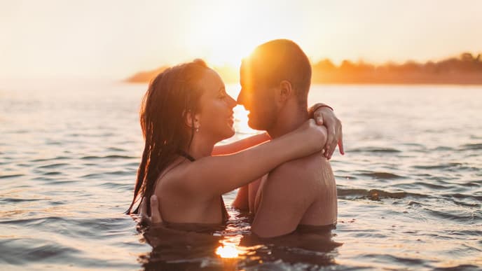 Mann und Frau küssen sich im Wasser