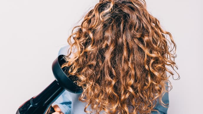 Frau föhnt sich kopfüber Haare