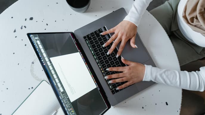 Person tippt auf Laptop