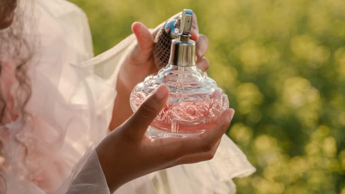 Frau mit Parfum Flakon in der Hand