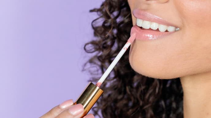 Frau trägt Lipgloss auf