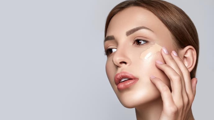 Frau trägt BB Cream im Gesicht auf