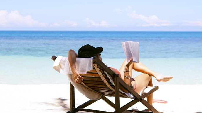 Frau liest Buch am Strand