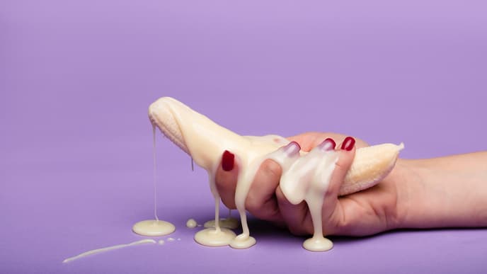 Banane in Hand und weiße Creme