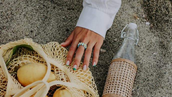Ring am Finger und Zitrone am Strand