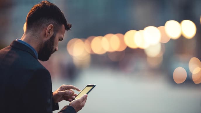 Mann schaut traurig auf Handy