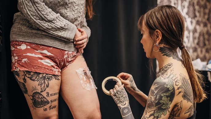 Tätowiererin foliert frisches Tattoo