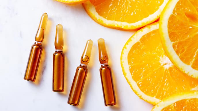Vitamin C Seren Flakons neben Orangenscheiben