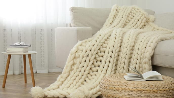Decke aus Merinowolle liegt auf dem Sofa