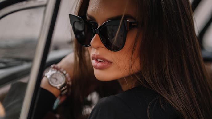 Frau mit Sonnenbrille sitzt im Auto