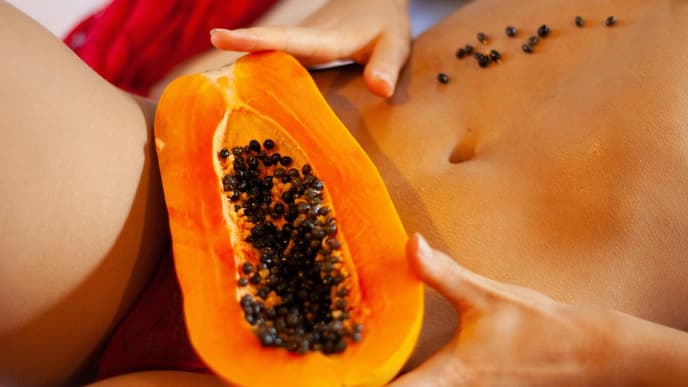 Frau mit Papaya zwischen den Beinen