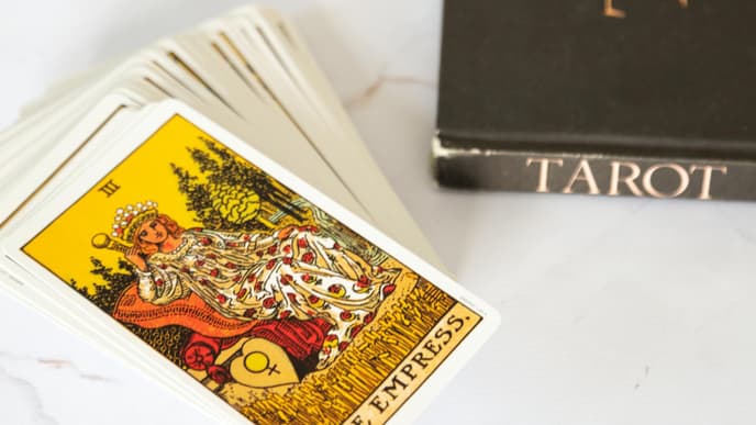 Tarot karten und ein Tarot Buch liegen auf einem Tisch