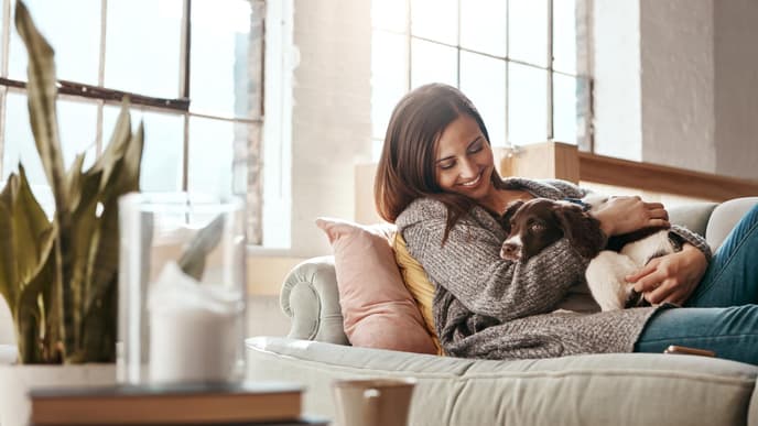 Frau mit Hund auf Sofa