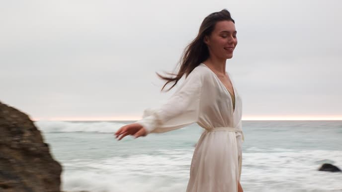Frau steht am Strand