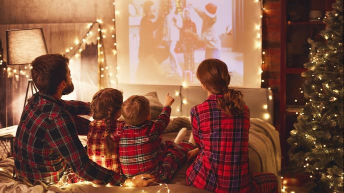 Familie schaut Weihnachtsfilme auf Beamer