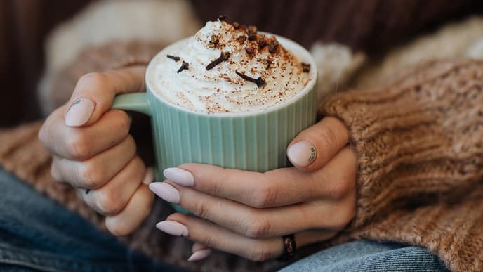 Frau hält Tasse mit Heißgetränk