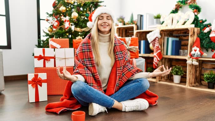 Frau meditiert vor dem Weihnachtsbaum