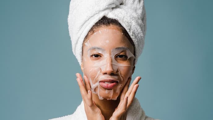 Frau im Bademantel mit Gesichtsmaske