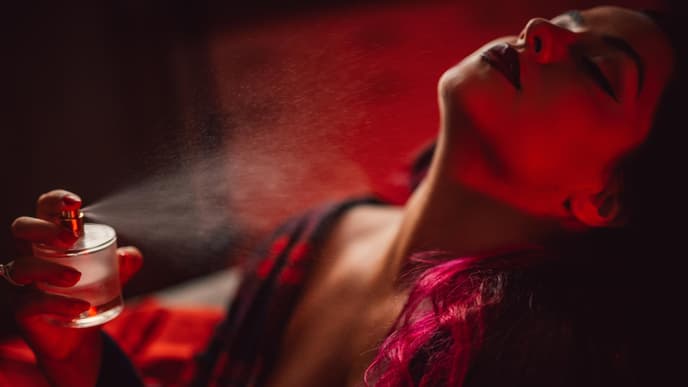 Frau sprüht sich Parfum an den Hals