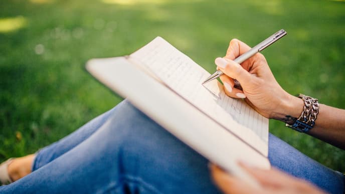 Frau schreibt in Notizbuch